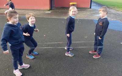 Senior Infants having fun playing a game from the past, called Elastics
